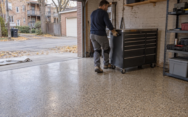 A tool chest rolled back onto a same-day polyaspartic flake floor in a detached Oak Park garage on a cold autumn afternoon.